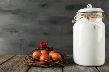 Ahşap masa ve koyu arka plan üzerinde yumurta ile süt olabilir
