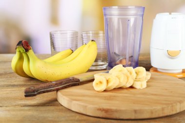 Parlak zemin üzerine ahşap masa üzerinde kesme tahtası üzerinde muz dilimlenmiş