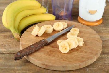 Ahşap arka plan üzerinde kesme tahtası üzerinde muz dilimlenmiş