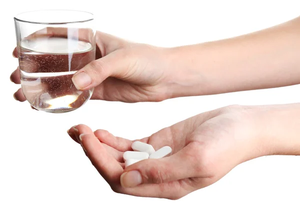 Mani con pillole e bicchiere d'acqua isolato su bianco — Foto Stock