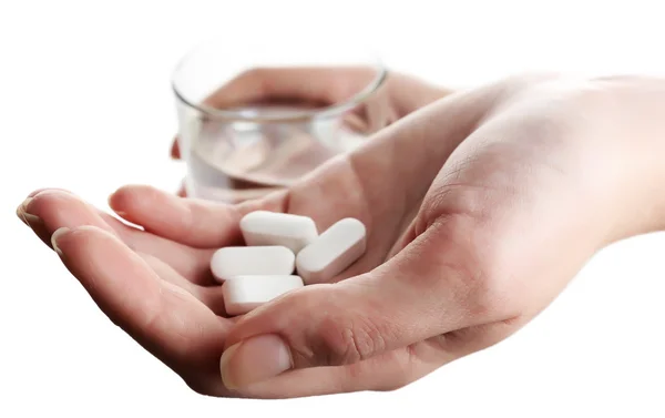 Hands with pills and glass of water isolated on white — Stock Photo, Image