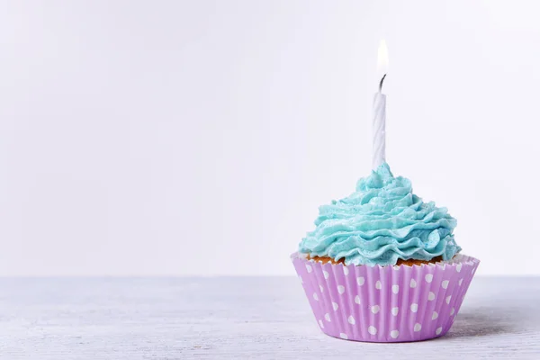 Delicioso cupcake de aniversário na mesa no fundo branco — Fotografia de Stock