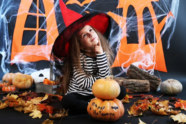 Küçük kız cadı Halloween süslemeleri arka plan üzerinde pumpkins ile şapkalı — Stok fotoğraf