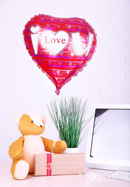 Miś z pudełko, roślin i miłość serce balonu na stół drewniany komputera, na tle ściany Cegła — Zdjęcie stockowe