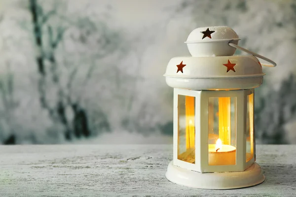 Lanterna na superfície de madeira e fundo de inverno — Fotografia de Stock