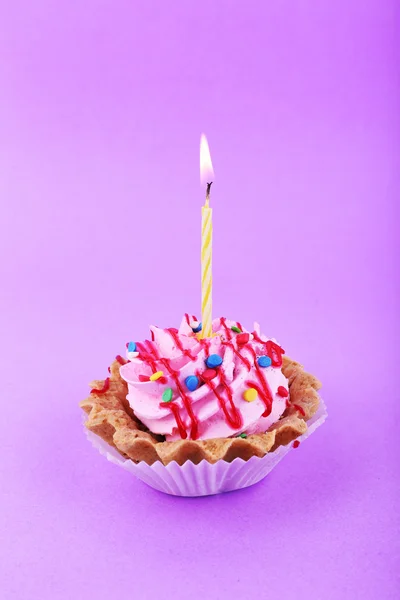 Pastel con vela de cumpleaños sobre fondo púrpura — Foto de Stock