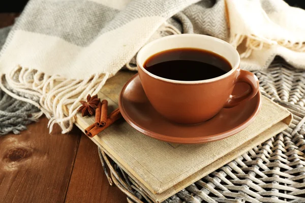 Cup of coffee on book near plaid on wooden table background — 图库照片