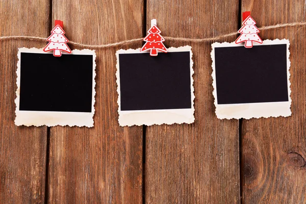 Lege fotokaders en Christmas decor op touw, op houten achtergrond — Stockfoto