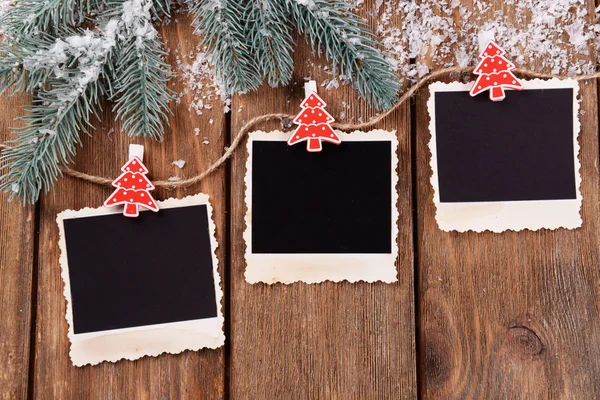 Molduras de fotos em branco e decoração de Natal com abeto de neve em fundo de mesa de madeira — Fotografia de Stock