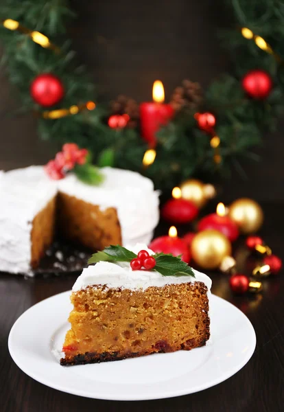 Rebanada de crema cubierta de pastel con decoración de Navidad sobre fondo de mesa de madera — Foto de Stock