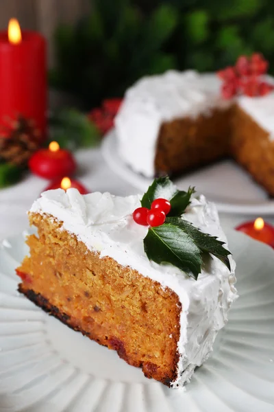 Deel van koek gedekt cream met Kerstdecoratie op tafel, op houten muur achtergrond — Stockfoto