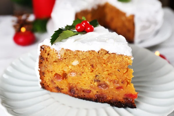 Fatia de bolo coberto de creme com decoração de Natal na mesa, no fundo da parede de madeira — Fotografia de Stock