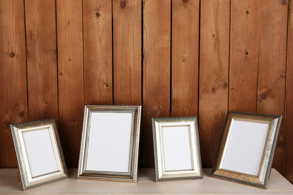 Photo frames on wooden surface and wooden wall background — Stock Photo, Image