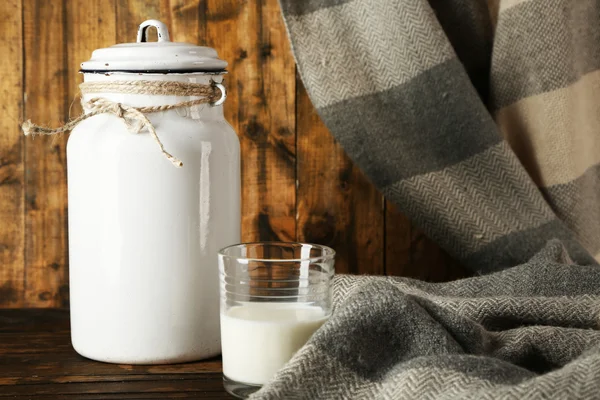 Milchkannen und Glasflaschen auf rustikalem Holzgrund — Stockfoto
