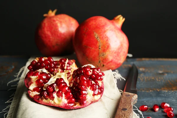 Sappige rijp Granaatappels op houten tafel, op donkere achtergrond — Stockfoto