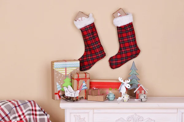 Hand-made Christmas gifts and decorations on fireplace in room — Stock Photo, Image
