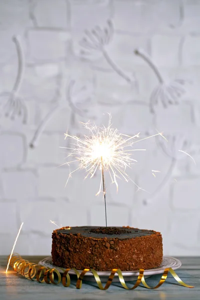 Torta gustosa con sparkler sul tavolo di legno — Foto Stock