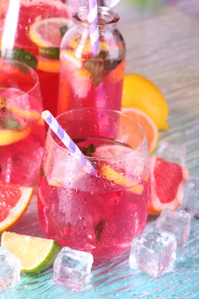 Limonada rosa en vasos y jarra sobre fondo brillante — Foto de Stock