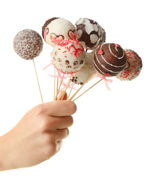 Weibliche Hand hält Cake Pops, isoliert auf weiß — Stockfoto