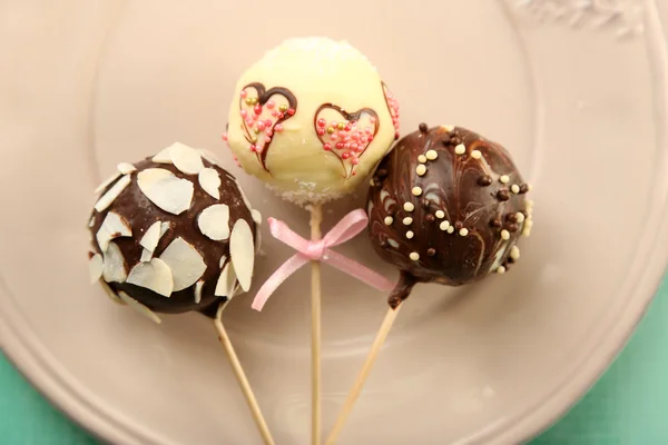 Leckere Cake Pops auf Teller, auf Holztisch — Stockfoto