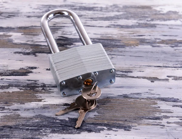 Padlock met toetsen op houten achtergrond — Stockfoto