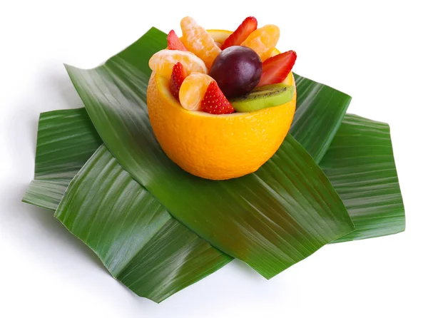 Fruit dessert in orange peel on green leaf isolated on white — Stock Photo, Image