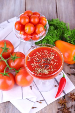 Kadehi ve peçete ahşap arka plan üzerinde taze sebze domates suyu