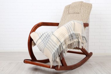 Ekose tuğla duvar arka plan yakınındaki ahşap zemin üzerinde sallanan sandalye kaplı