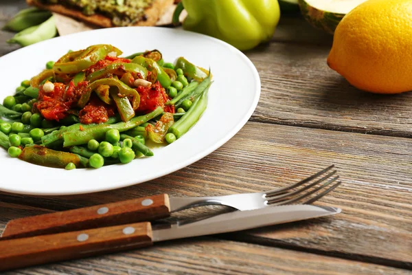 Healthy salad with peas and asparagus served on wooden table, close-up — Stock Photo, Image