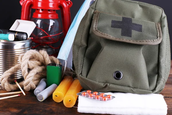 Emergency preparation equipment on wooden table, on dark background — Stock Photo, Image