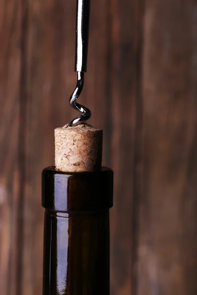 Ouverture de bouteille en gros plan, sur fond bois — Photo