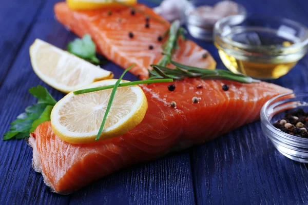 Salmón fresco con especias y limón sobre mesa de madera — Foto de Stock