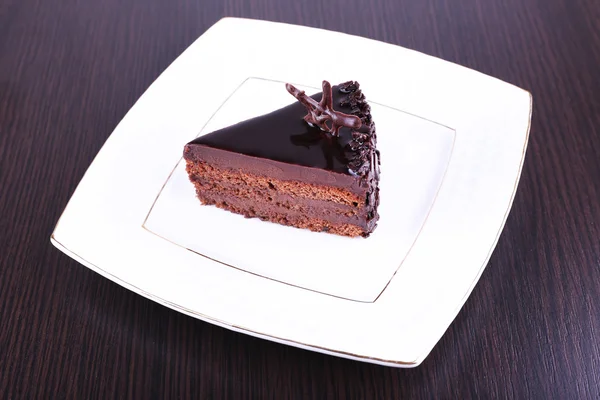 Delicioso pastel de chocolate en el plato en la mesa — Foto de Stock