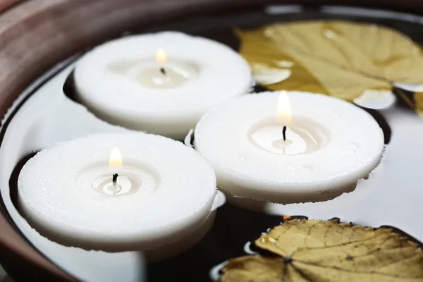 Baum weiße Kerzen schwimmend mit Blättern auf Wasser in Schüssel — Stockfoto