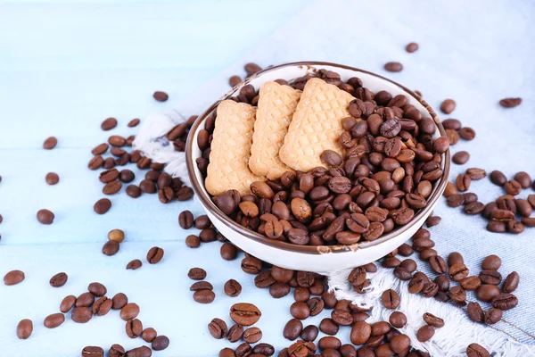 Ciotola di biscotti frolla e chicchi di caffè su sfondo blu in legno con materiale jeans — Foto Stock