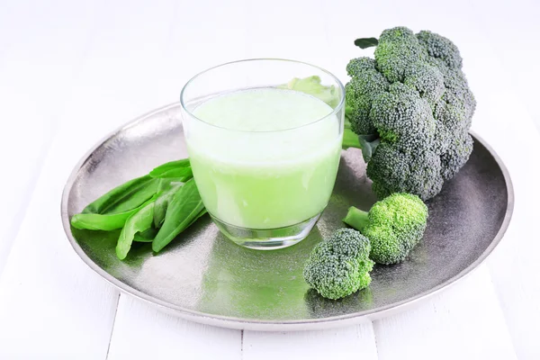 Glass of fresh green juice with vegetables on metal tray, on wooden surface background — Stock Photo, Image