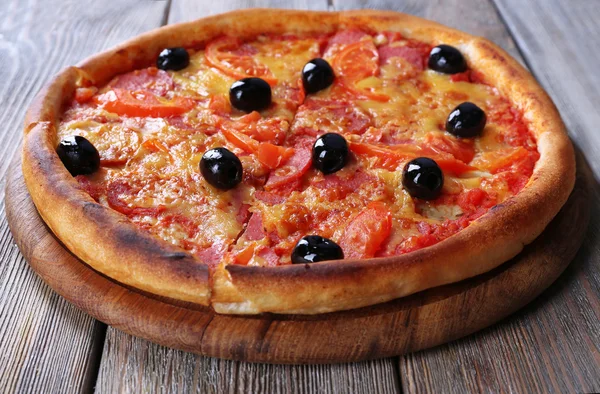 Delicious Italian pizza with black olives on wooden table background — Stock Photo, Image