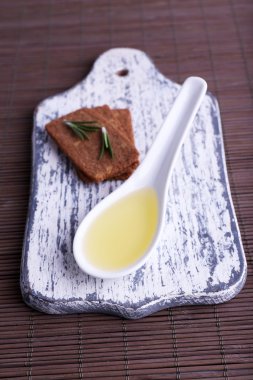 Crispbread dal biberiye kesme tahtası üzerinde ve bambu Hasır arka plan üzerine kaşık ile