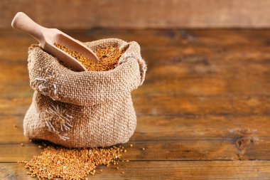 Ahşap arka plan üzerinde çantaya hardal tohumu