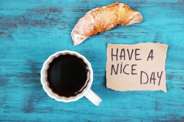 Kahve, taze kruvasan ve ahşap arka plan kartında kağıt kompozisyon