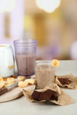 Parlak zemin üzerine ahşap masa üzerinde muz kesme tahtası ve kıyılmış çikolata, dilimlenmiş