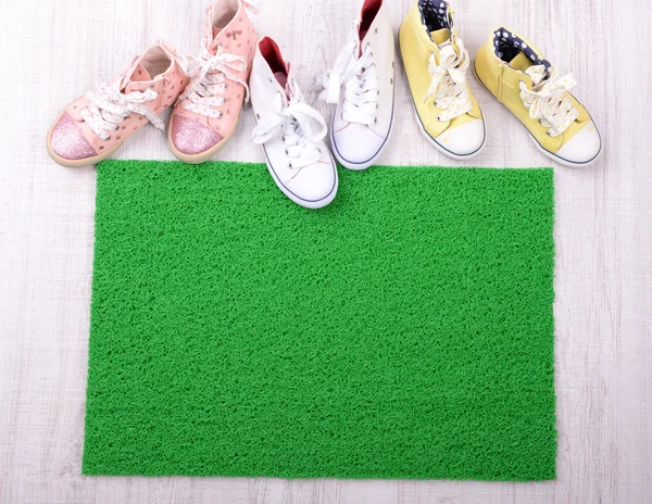 Green carpet on floor and converse close-up — Stock Photo, Image