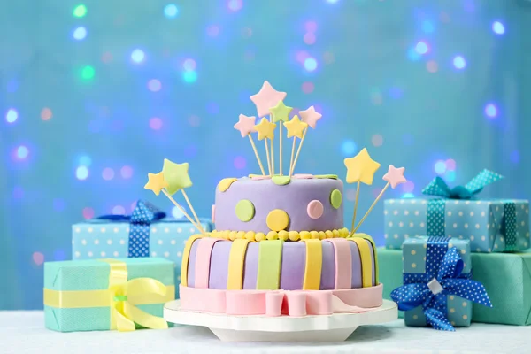 Delicioso bolo de aniversário no fundo azul brilhante — Fotografia de Stock