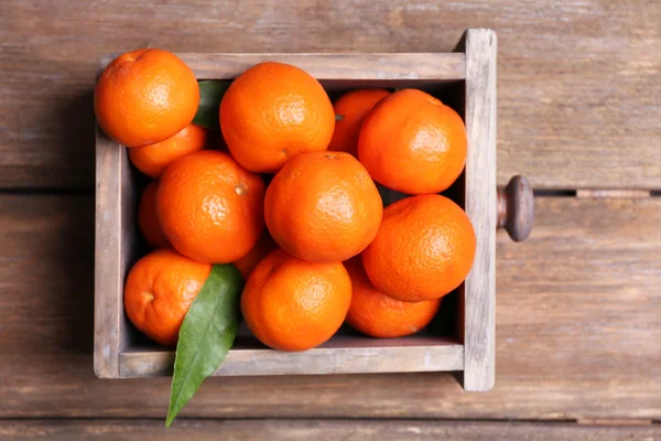 Mandarins maduros frescos em caixa de madeira, sobre fundo de madeira — Fotografia de Stock