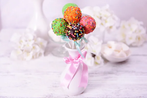 Söta cake pops i vas på bordet på ljus bakgrund — Stockfoto