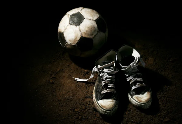 Soccer ball on ground on dark background — Stock Photo, Image