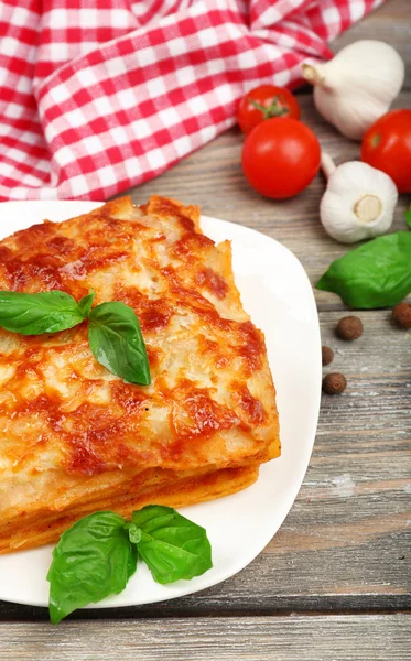 Część pysznych lasagne na drewnianym stole — Zdjęcie stockowe