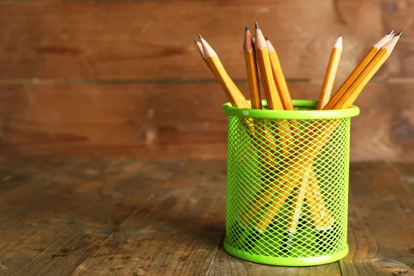 Pencils in metal holder on rustic wooden background — Stock Photo, Image