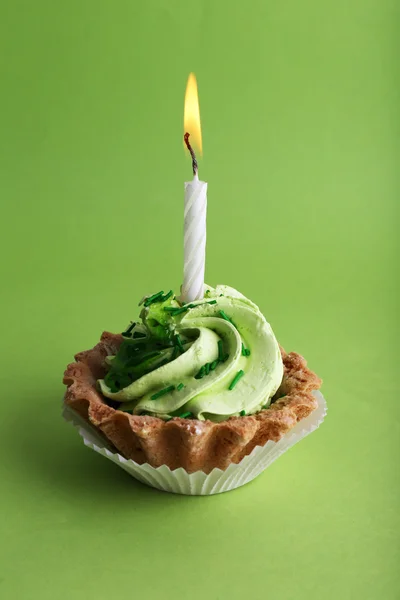 Narozenin cup dort se svíčkou na zeleném pozadí — Stock fotografie