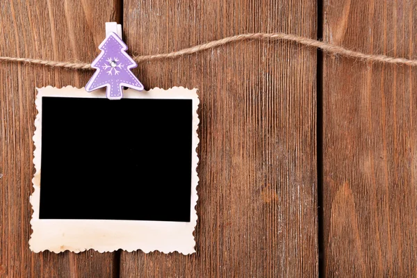 Marco de fotos en blanco y decoración de Navidad en cuerda, sobre fondo de madera —  Fotos de Stock